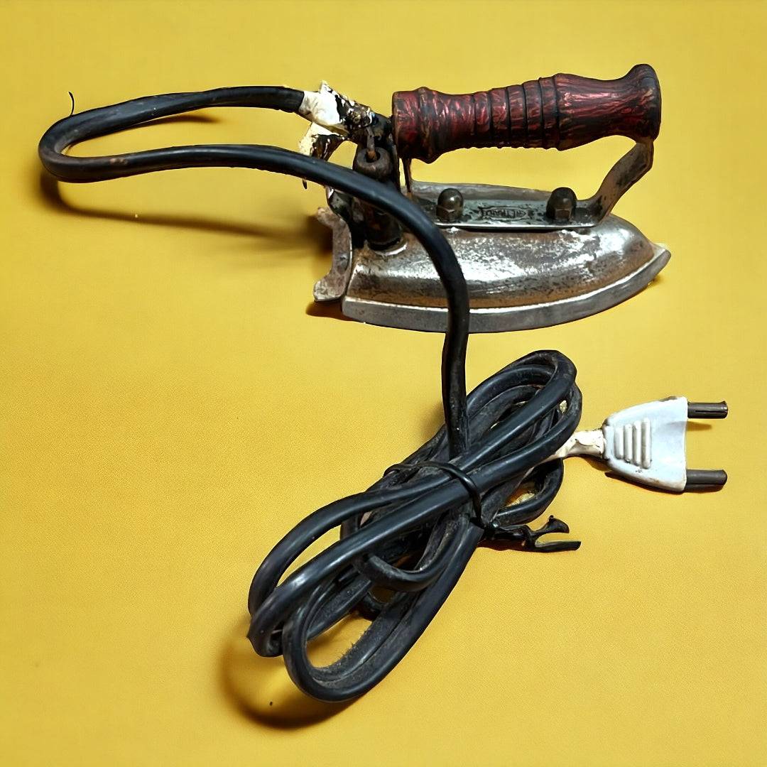 Plancha Eléctrica Vintage de 125V con mango de madera y cable enrollado, ideal para decoración retro en el hogar o colección temática.