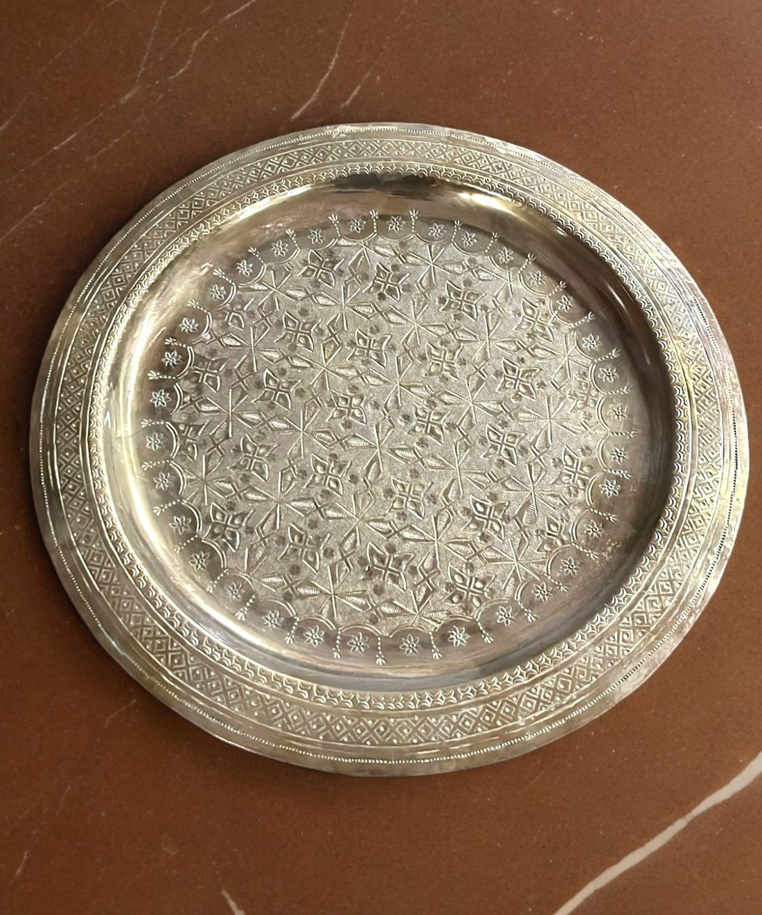 Bandeja metálica decorativa con diseño árabe grabado, ideal para servir o embellecer espacios. Fabricada en metal resistente, mide 30x30 cm.