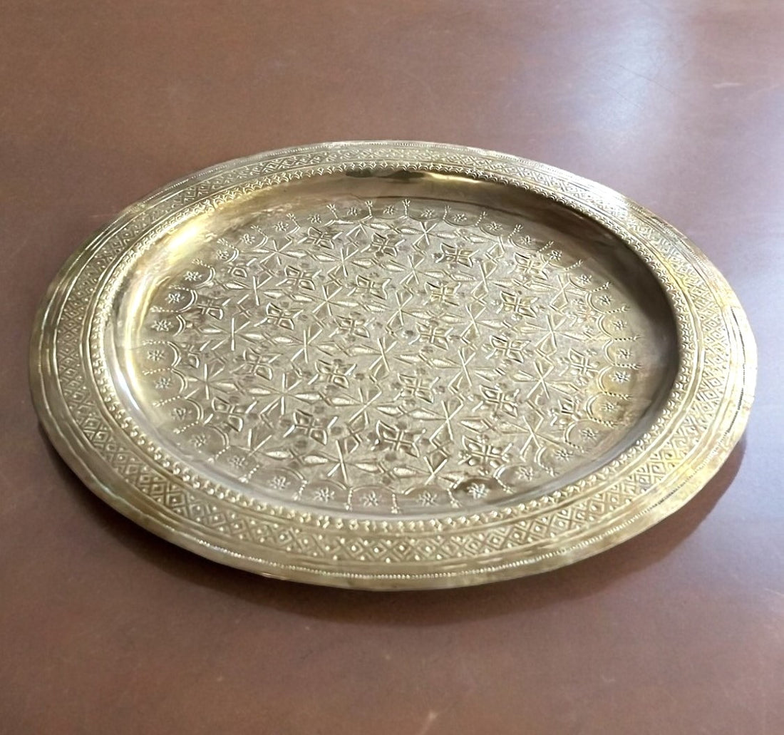 Bandeja metálica decorativa con diseño árabe grabado, ideal para servir o embellecer espacios. Fabricada en metal resistente, mide 30x30 cm.