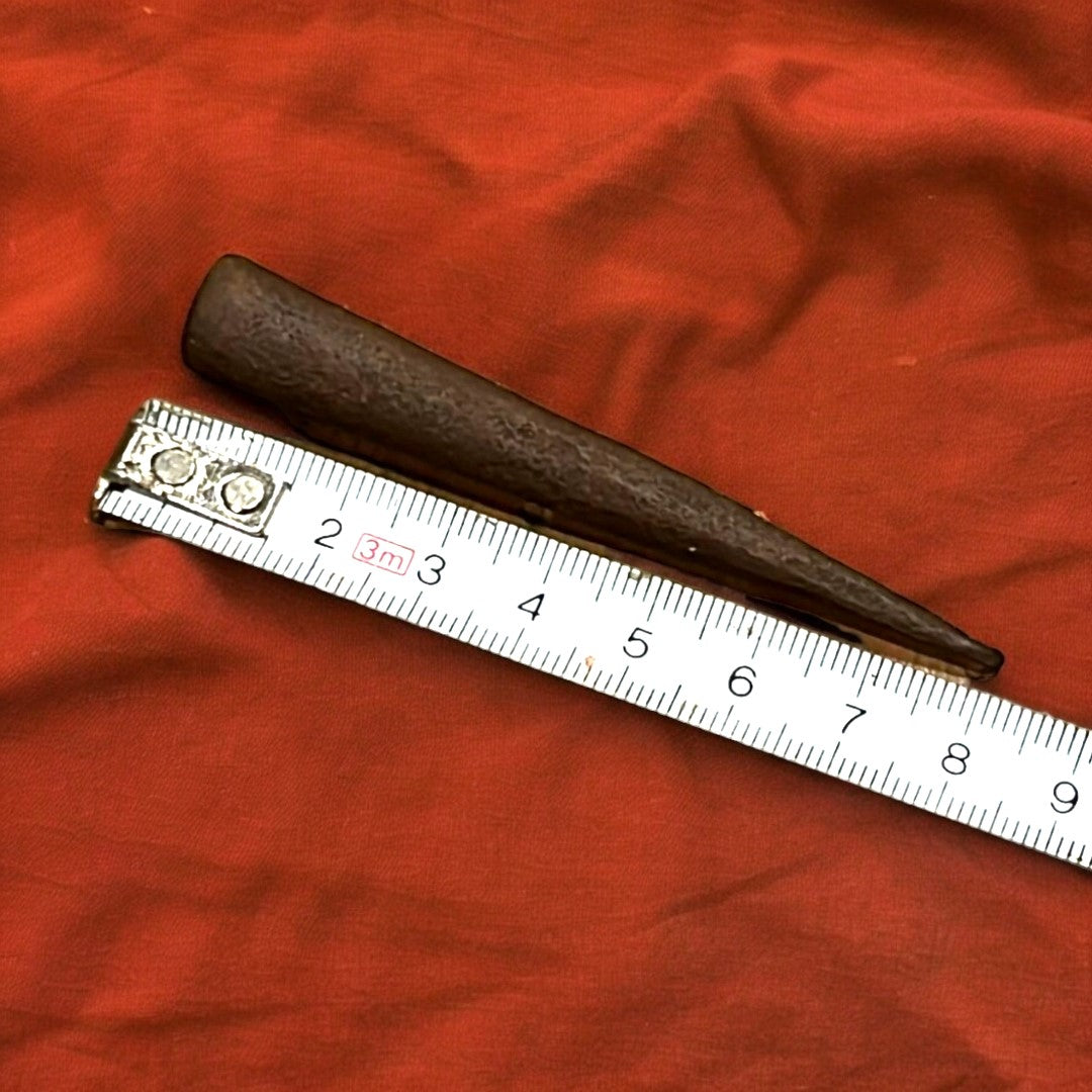 Clavos Sin Cabeza antiguos dispuestos en abanico sobre tela marrón. Ideales para decoraciones rústicas y restauraciones históricas.