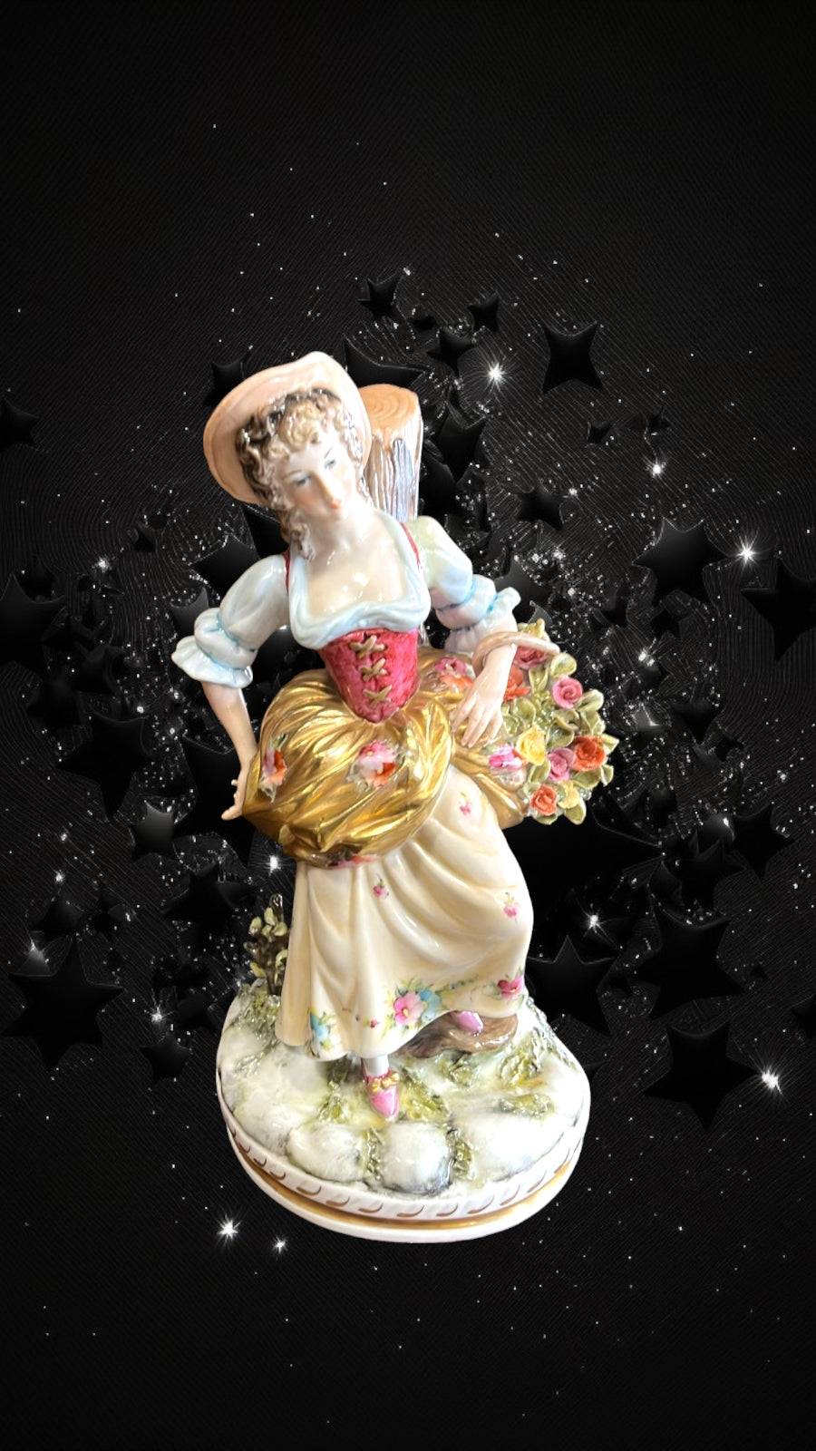 Figura Dama con Flores de porcelana elegante, vestida con traje clásico y sombrero, ideal para decoración artesanal en hogar o jardín.
