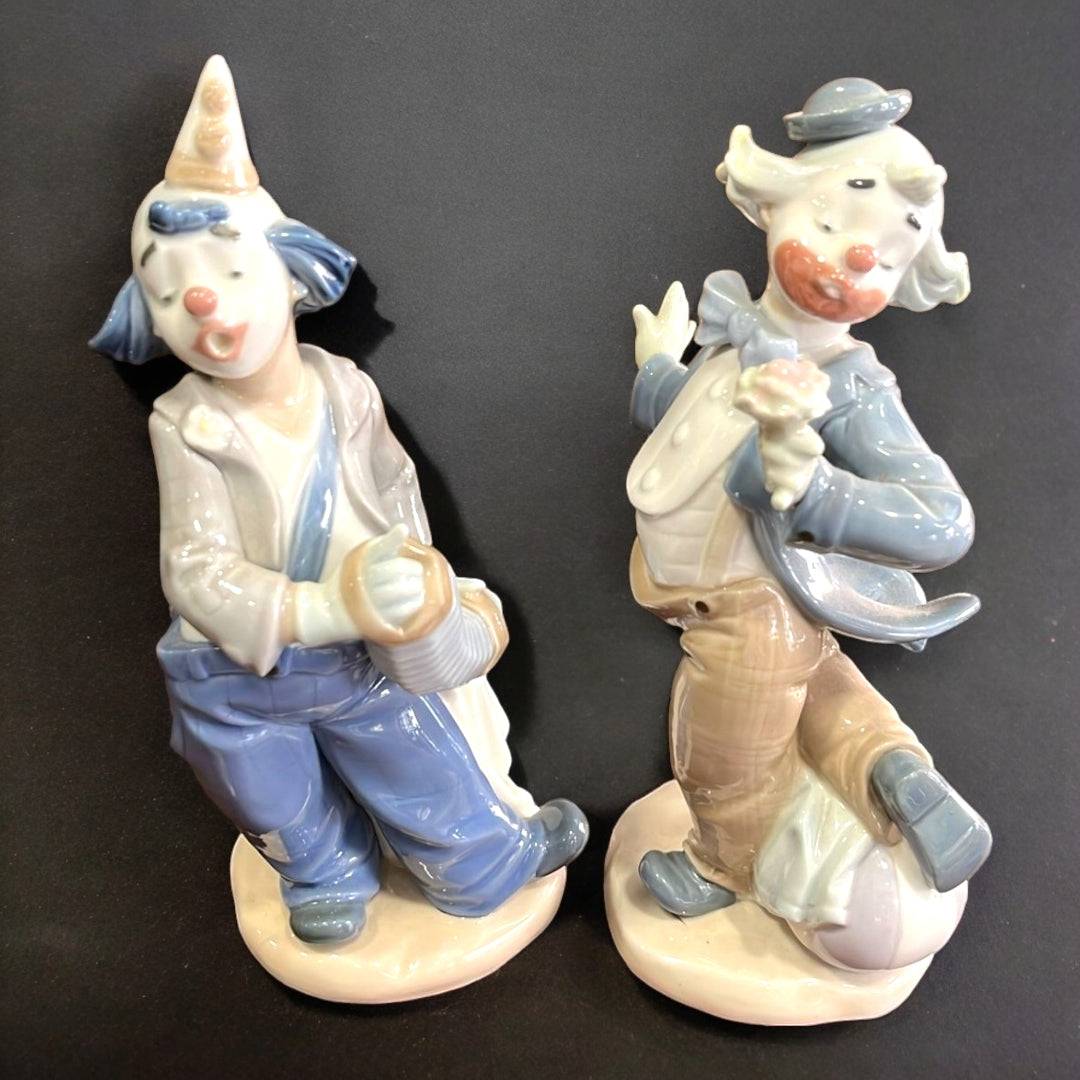 Figuras de porcelana Nao-Lladró: Payaso con flor y Payaso con acordeón en tonos pastel, ideales para decoración de interiores elegantes.