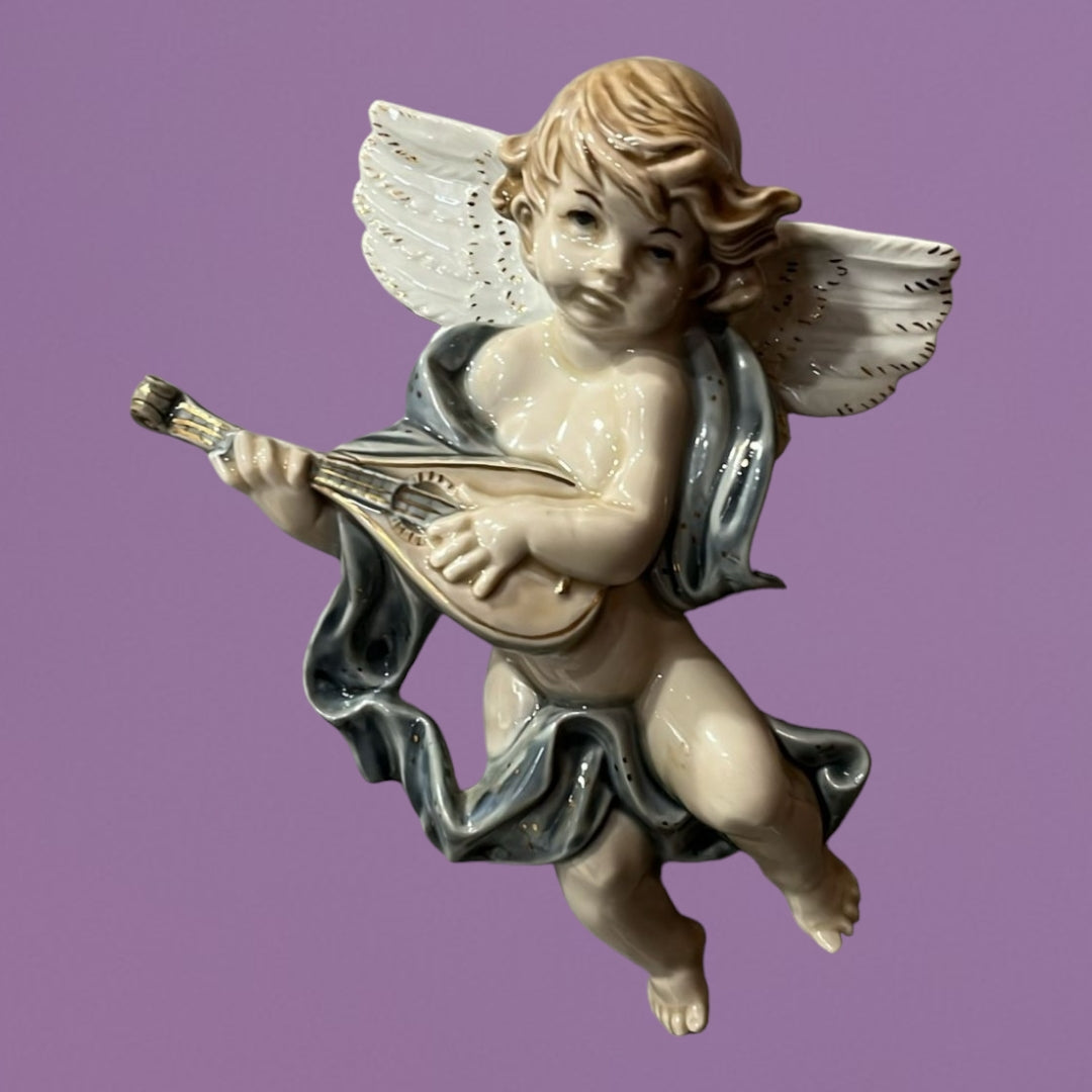 Ángeles músicos de porcelana para pared en fondo azul, con detalles elegantes y armoniosos. Decoración ideal para el hogar.