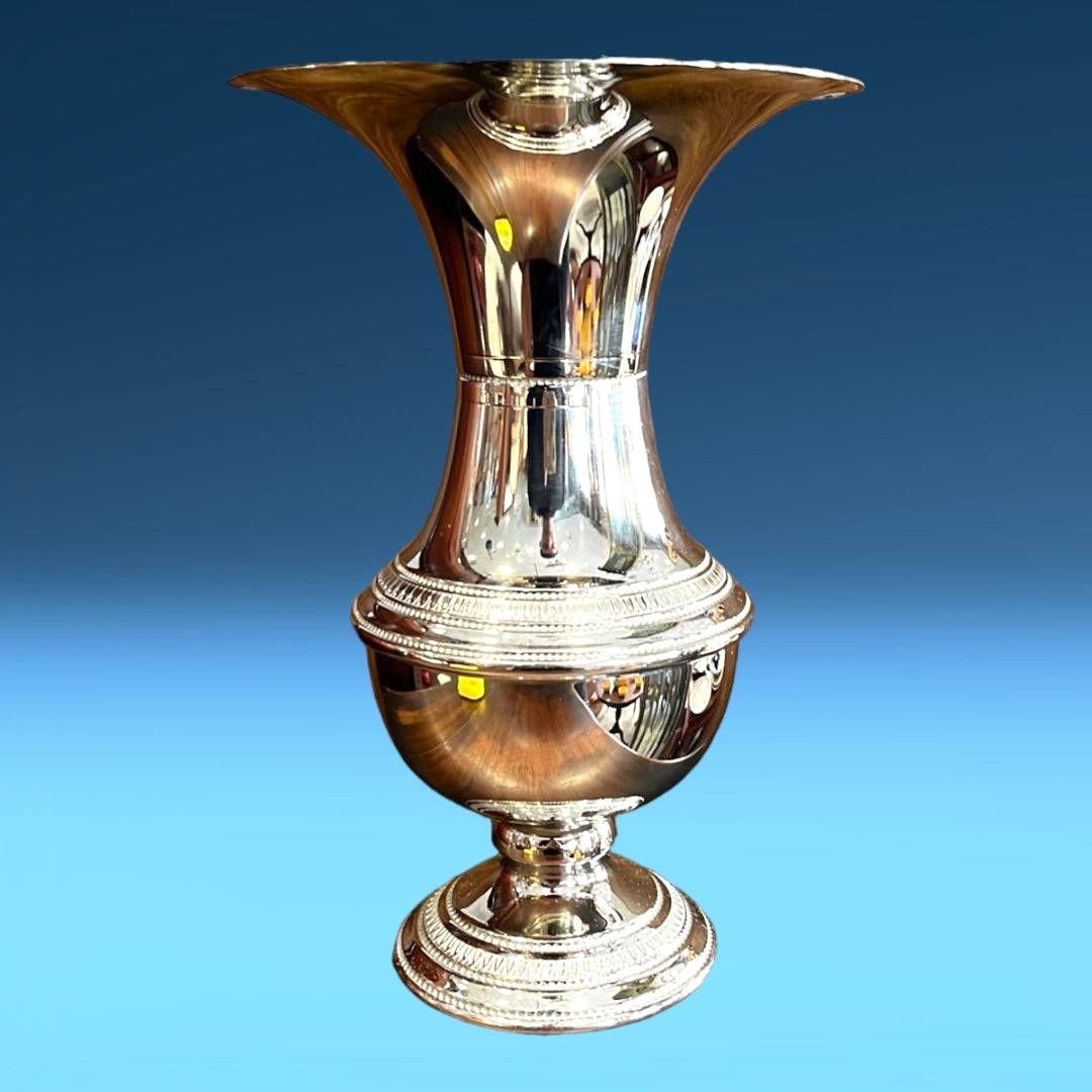 Florero plateado de alpaca con acabado brillante y diseño elegante, ideal para decoración de interiores con glamour y estilo moderno.