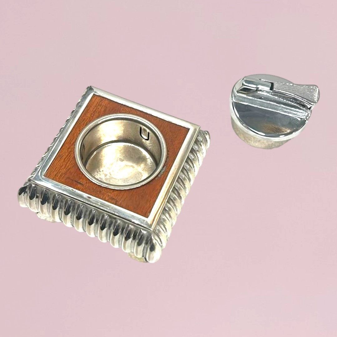 Mechero Escritorio en metal plateado con diseño cuadrado y detalles en madera, ideal para decoración elegante en oficina o sala.