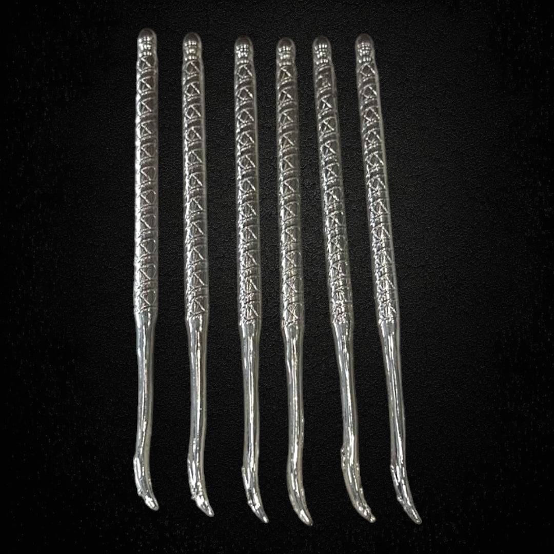 Juego de seis palillos antiguos en metal plateado para caracoles o mariscos, con mango decorativo grabado. Ideal para decoración vintage.