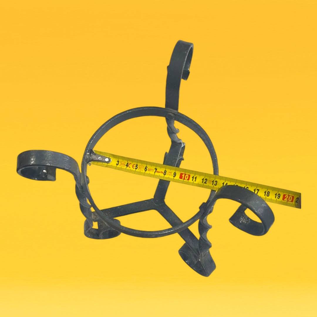 Macetero de hierro forjado decorativo con diseño de espirales, ideal para plantas pequeñas en interiores o jardines.