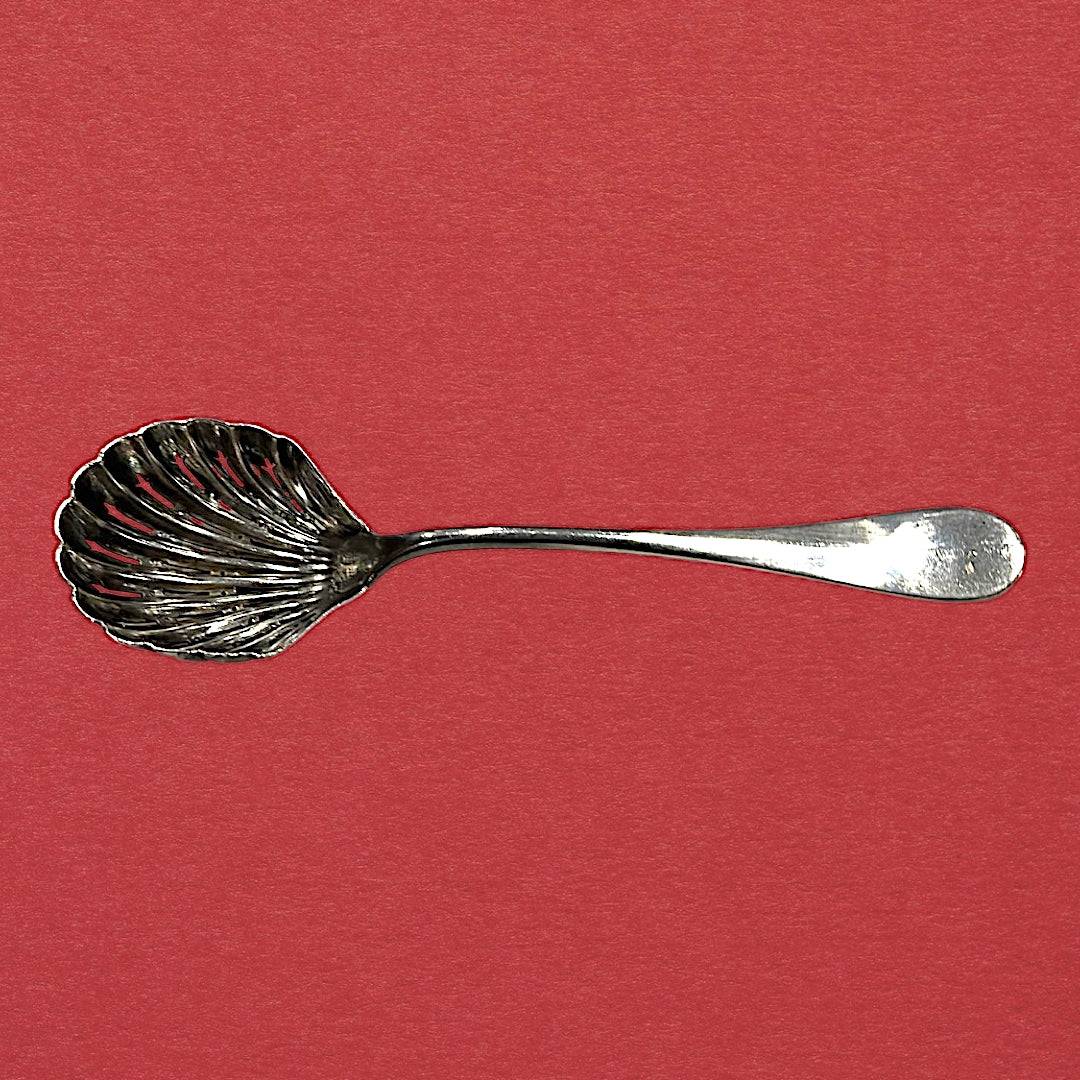 Cuchara de servir estilo vintage con forma de concha calada, pieza decorativa de alpaca para coleccionistas y mesas elegantes.