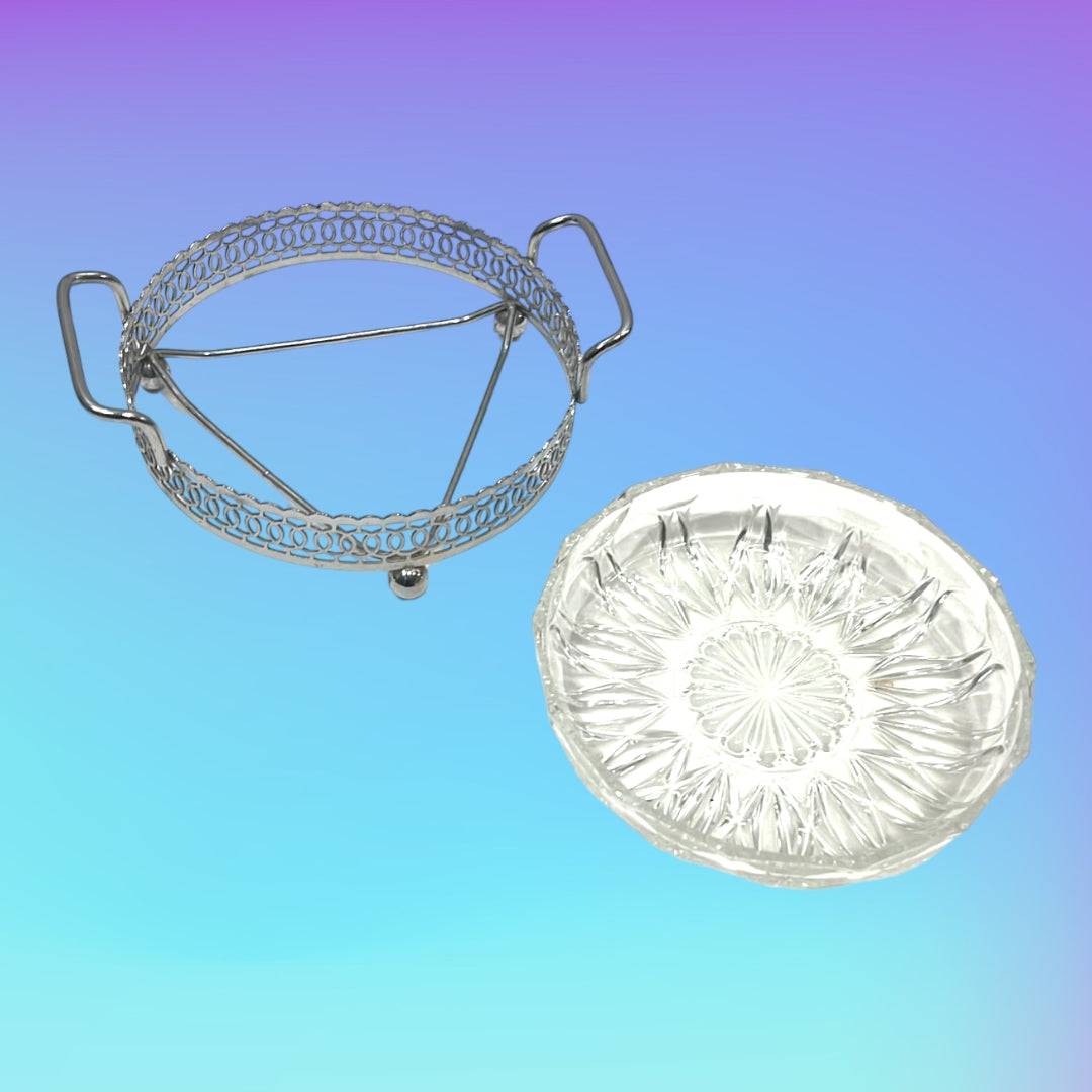 Entremesera de metal plateado y cristal con asas laterales sobre fondo degradado. Diseño clásico ideal para decoración de eventos elegantes.