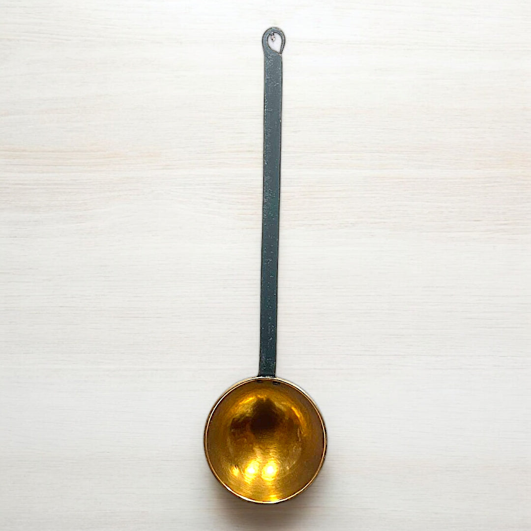 Cazo de latón antiguo con mango de hierro largo y diseño rústico, ideal para decoración vintage en cocinas o comedores. Pieza exclusiva de CositasAntiguas.es.