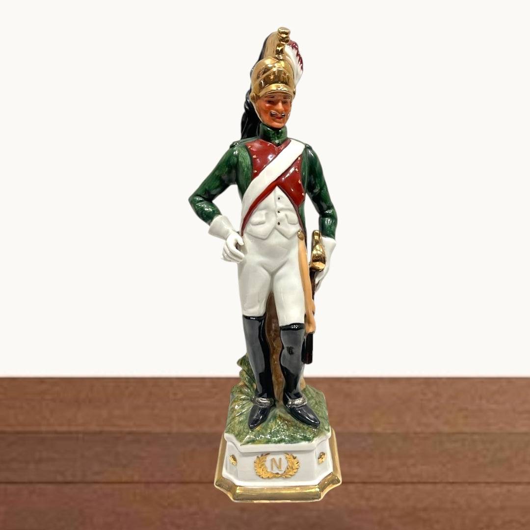 Figura Dragón Militar Porcelana - Napoleónica multicolor y dorado, con uniforme detallado y base decorativa con la letra N dorada.
