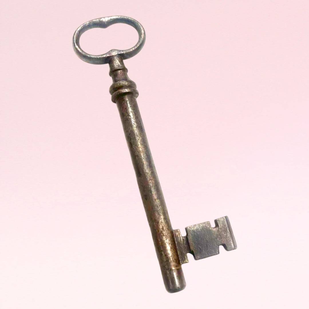 Llave antigua de forja con diseño clásico y acabado metálico, perfecta como adorno vintage en espacios interiores del hogar.