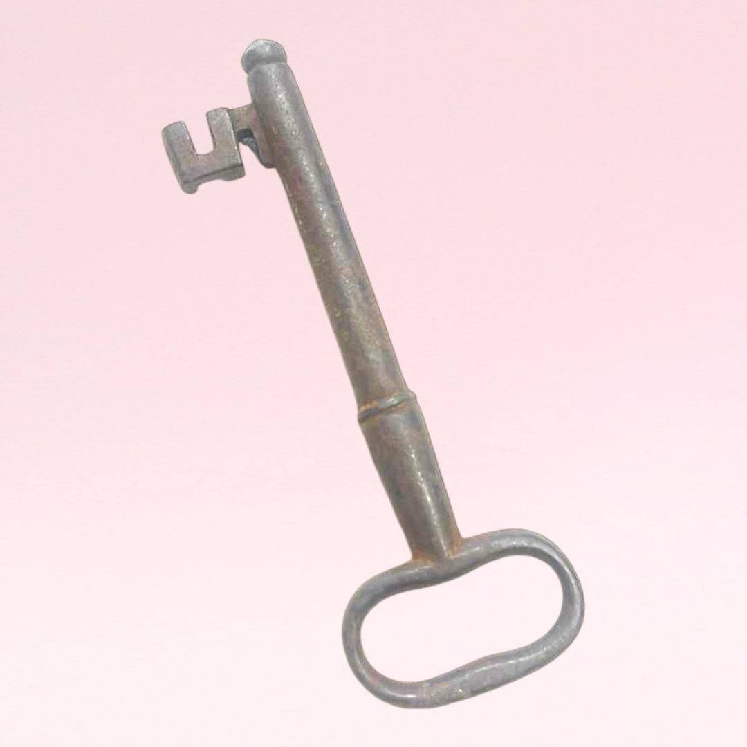 Rara llave antigua de forja con diseño robusto y acabado envejecido, ideal como elemento decorativo vintage para el hogar.