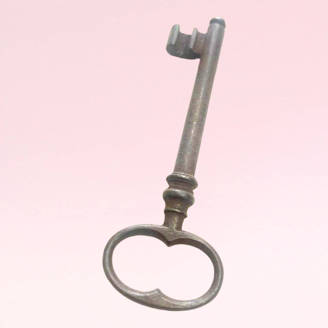 Llave antigua de forja con diseño clásico y acabado envejecido, ideal para decoración vintage en el hogar o jardín.