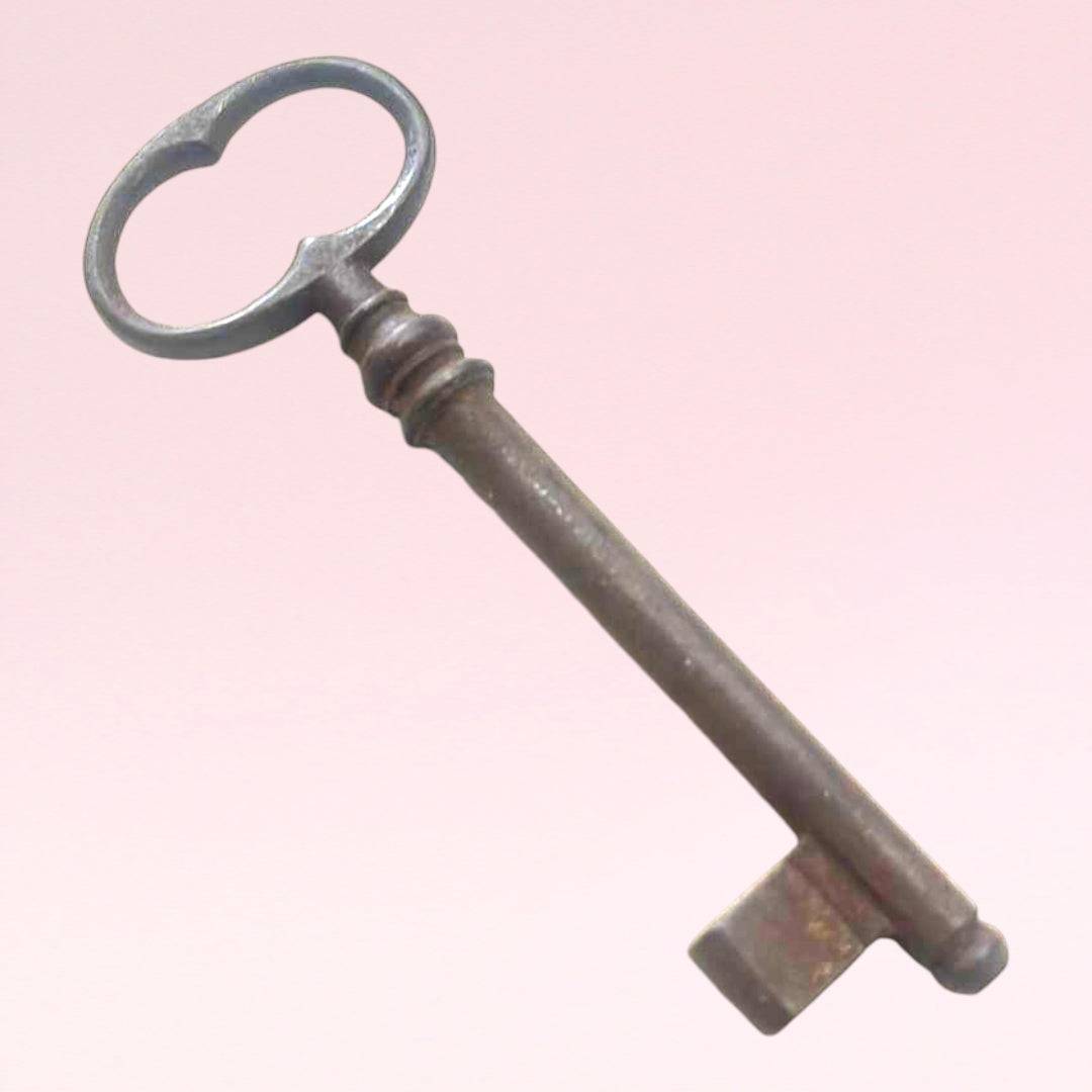Llave antigua de forja con diseño clásico y acabado envejecido, ideal para decoración vintage en el hogar o jardín.