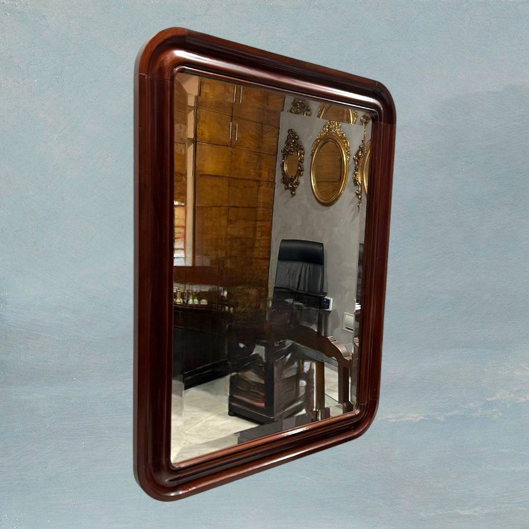 Espejo vintage con marco de caoba, estilo y elegancia atemporal, colgado en pared azul con reflejo de oficina clásica. Ideal para decoración de interiores.