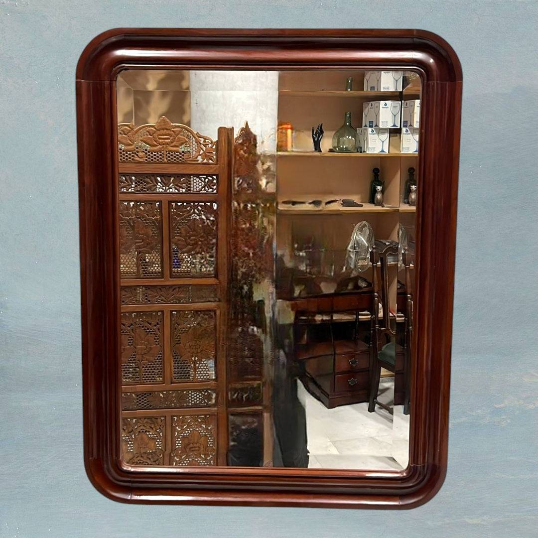 Espejo vintage con marco de caoba, estilo y elegancia atemporal, reflejando biombo tallado y estantería. Perfecto para dormitorios con decoración clásica.