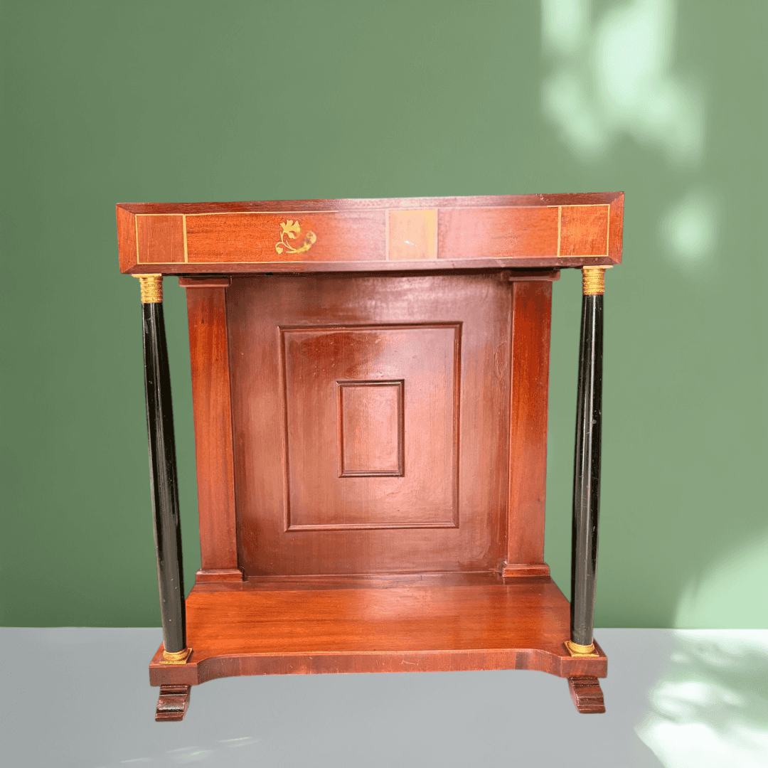 Mueble auxiliar de estilo Imperio con estructura de caoba y frente decorado.