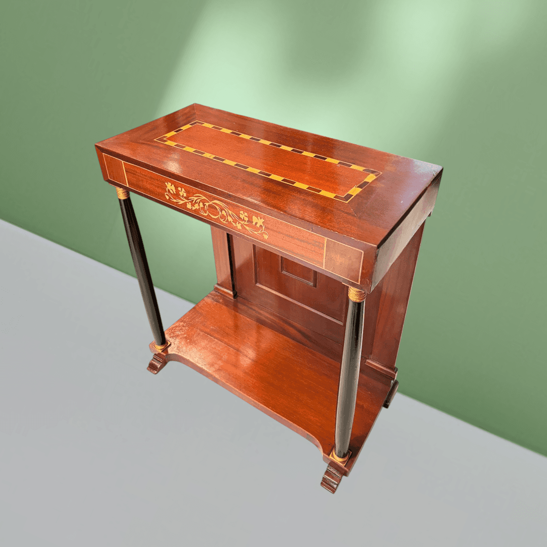 Vista frontal de consola antigua con panel trasero moldurado y balda inferior.