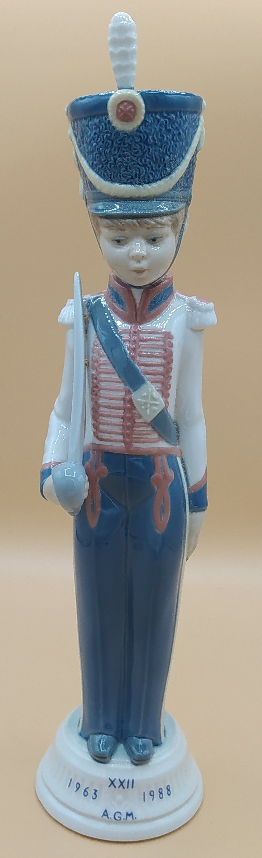 Figura de porcelana Lladró Soldado Cadete con Espada, años 80, en uniforme azul y blanco con base marcada 1963-1988 A.G.M.