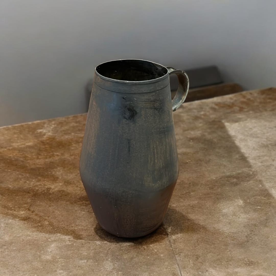 Jarra arrumbador de hierro con diseño rústico y acabado envejecido, ideal para decoración de interiores en estilo vintage.