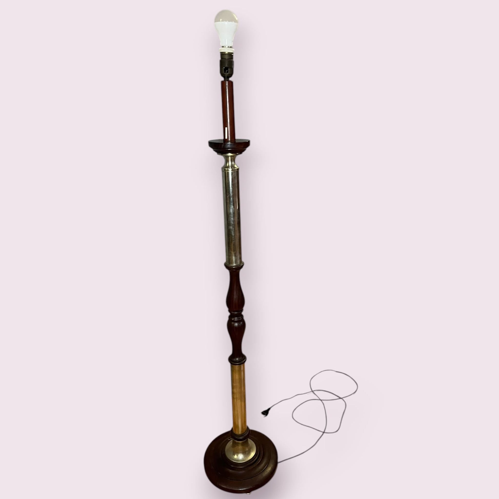 Detalle del pie de madera torneada de la lámpara de pie clásica.