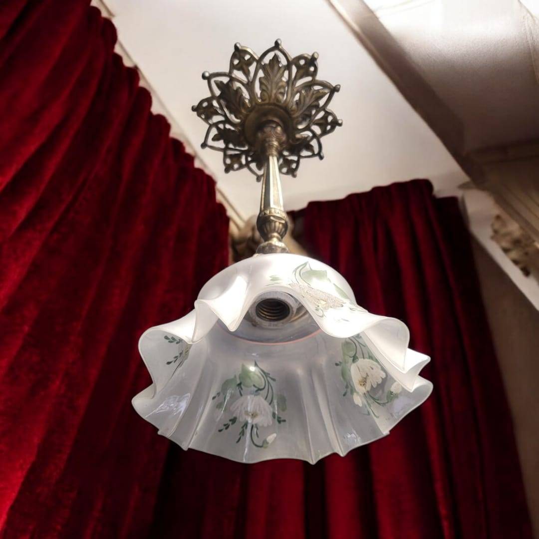 Lámpara de techo vintage con pantalla de vidrio ondulado y flores pintadas a mano, perfecta para ambientes con cortinas de terciopelo rojo.