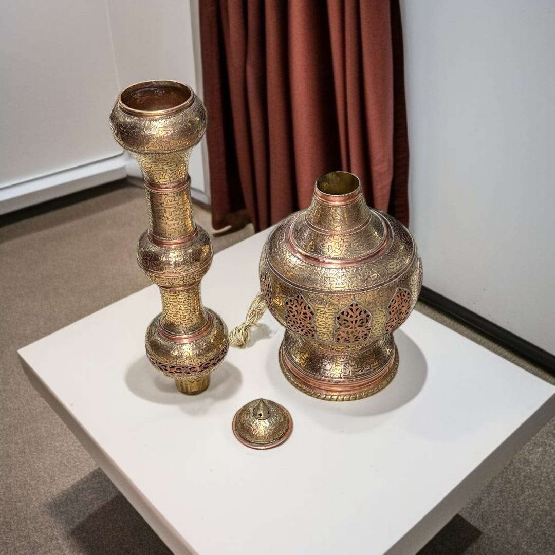 Lampara India antigua de metal y cobre artesanal única, desmontada en tres piezas sobre mesa blanca, con grabados orientales detallados.