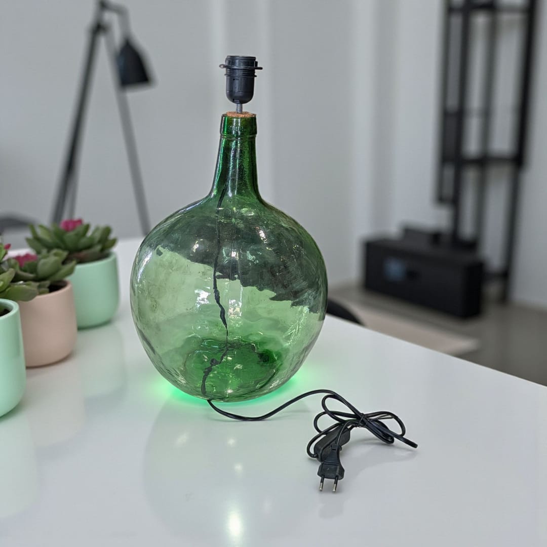 Lámpara de sobremesa elaborada con damajuana antigua de cristal verde.
