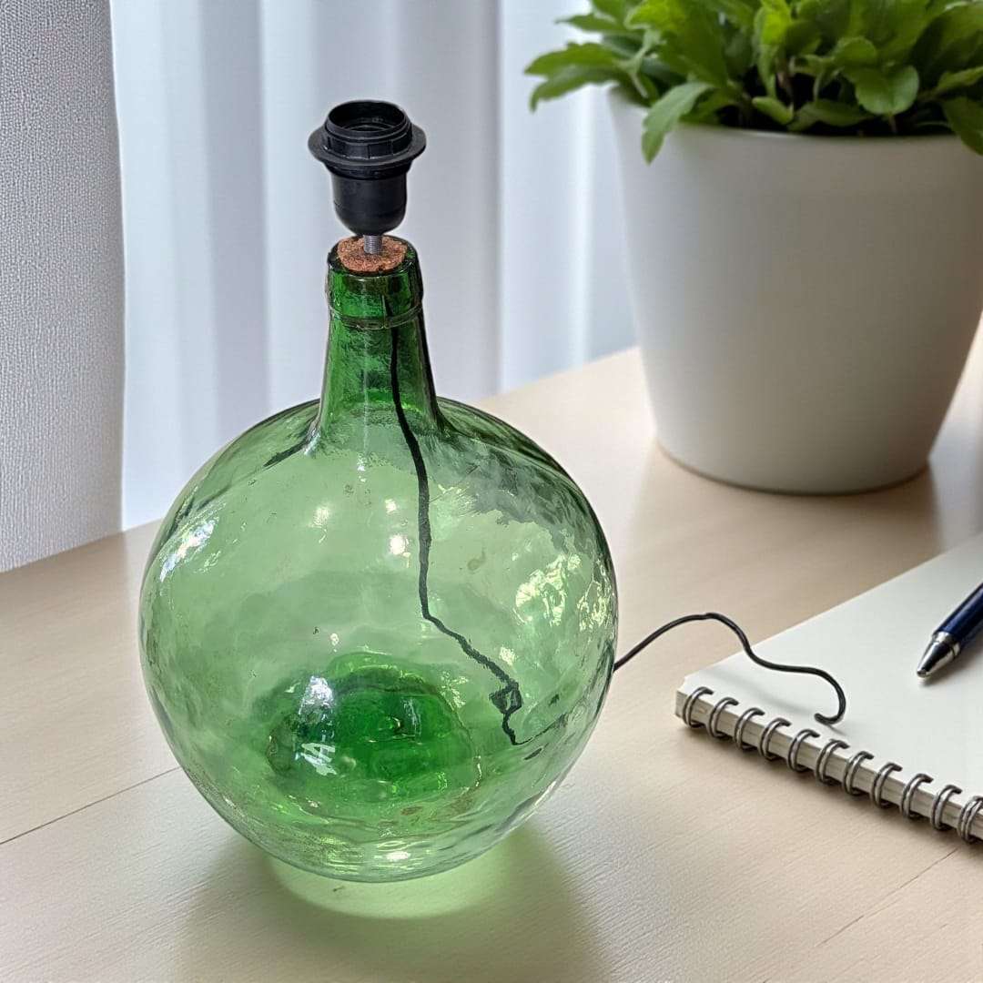 Lámpara damajuana antigua iluminando un ambiente rústico.