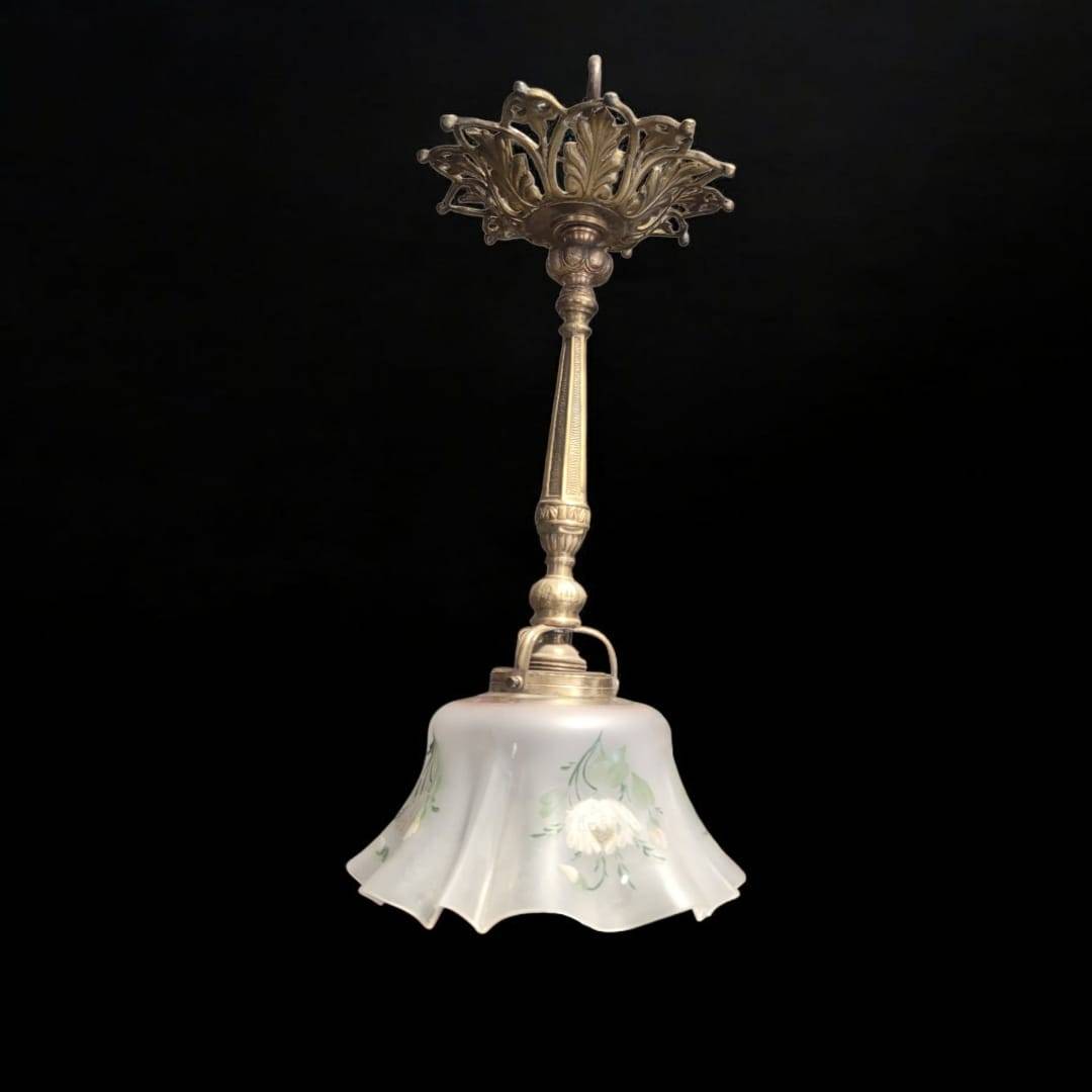 Lámpara de techo vintage con tulipa de vidrio floral y base de metal calado, destacada sobre fondo negro para mostrar su diseño clásico.