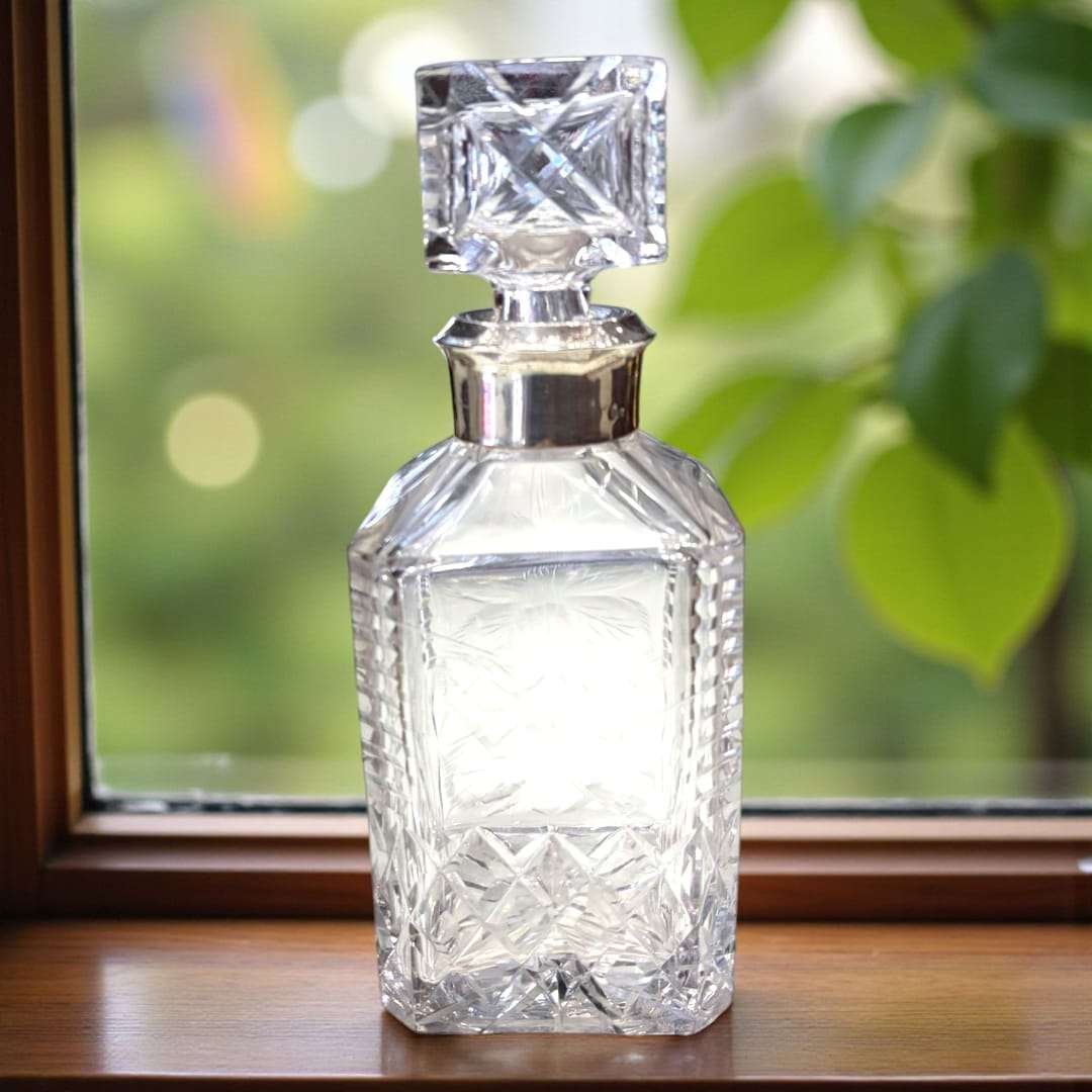 Licorera de cristal con cuello de plata auténtica.