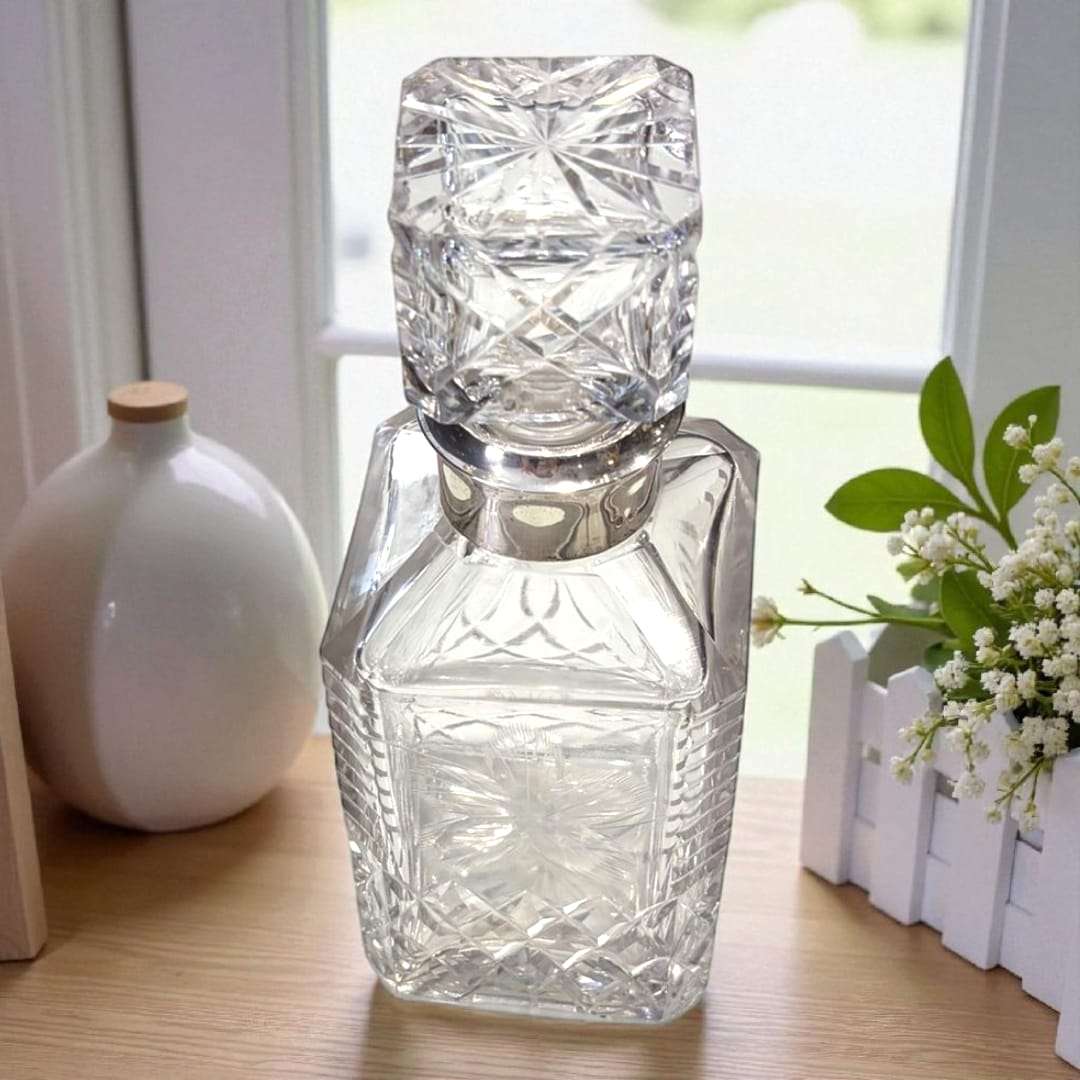 Licorera de cristal con cuello de plata auténtica.