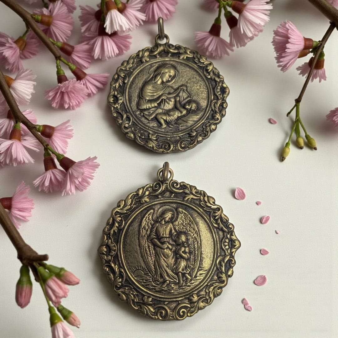 Medallas de metal fundido con relieves religiosos únicos, una con la Virgen y el Niño Jesús y otra con el Ángel de la Guarda y una niña. Decoración artesanal sacra para el hogar.