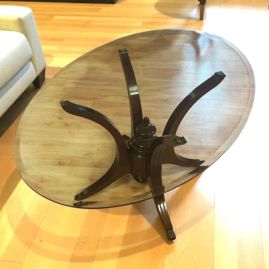 Mesa ovalada de cristal con patas curvas de caoba tallada. Diseño elegante único para decoración de interiores con estilo clásico.