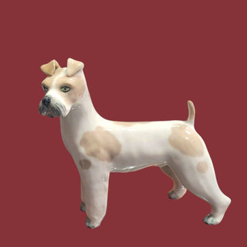 Perro de porcelana Lladró, figura decorativa única con manchas beige y expresión realista, ideal para decoración de interiores.