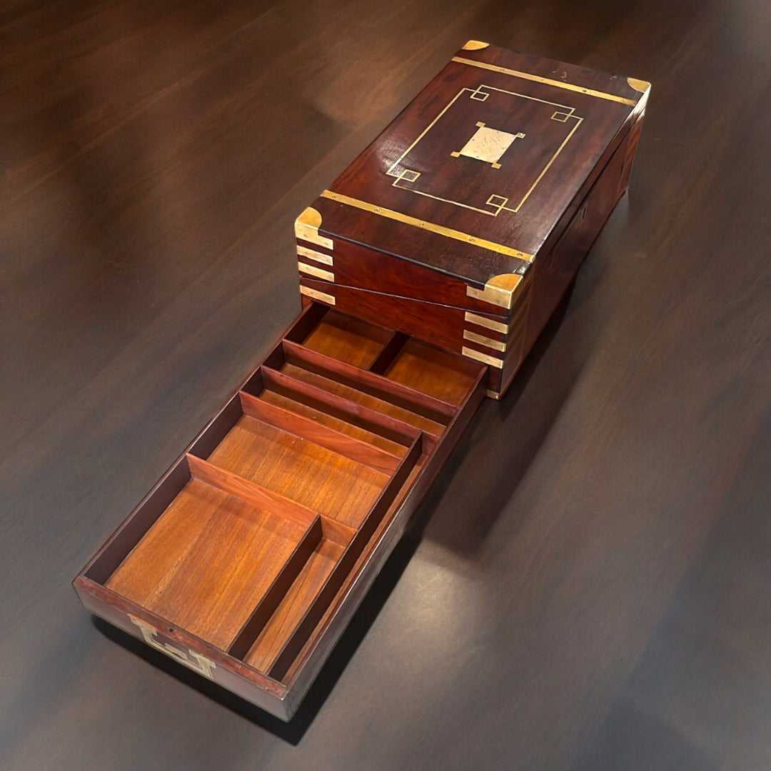 Escritorio de Campaña de caoba con detalles en latón, diseño rectangular y acabado brillante. Decoración funcional con historia del siglo XIX.