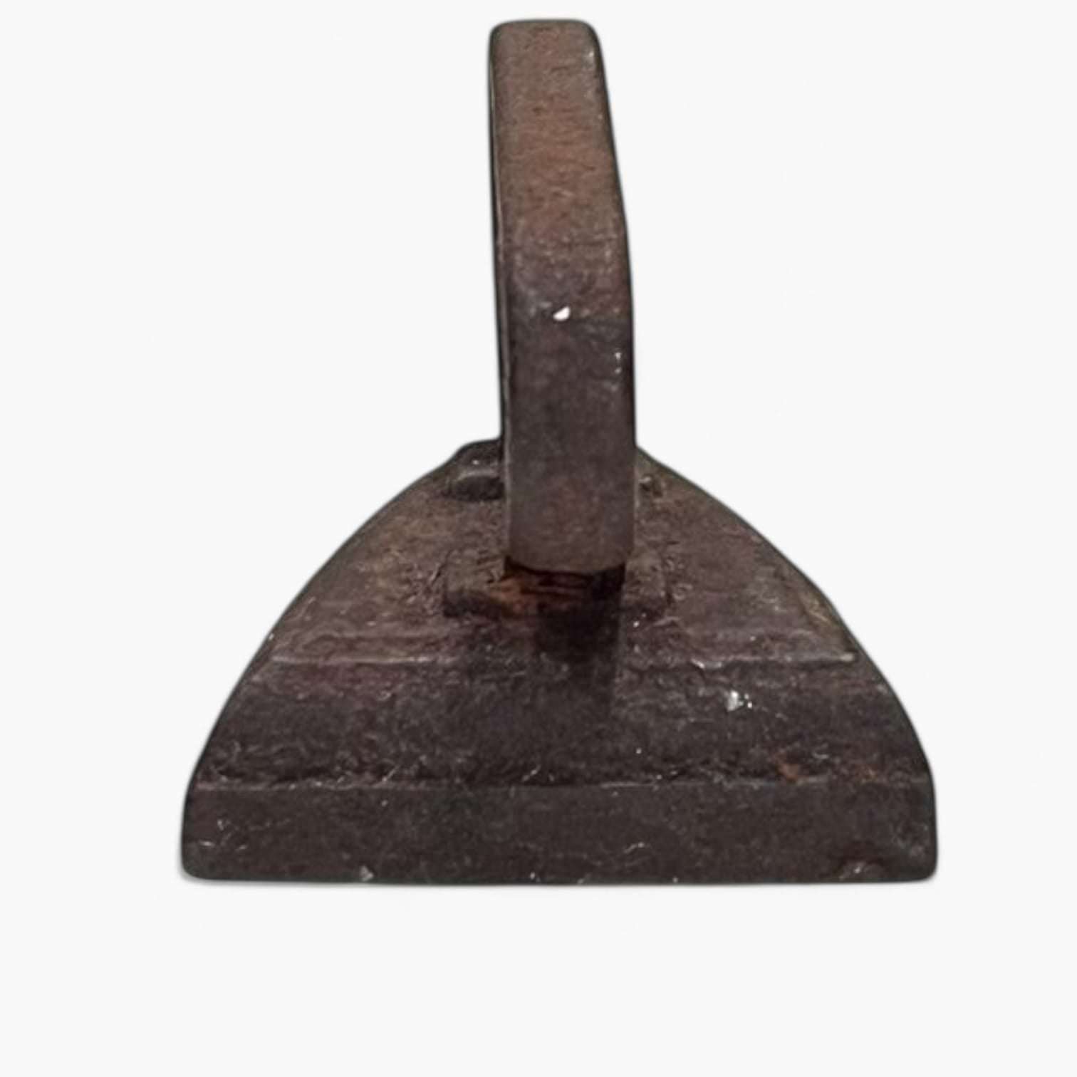 Vista frontal de plancha antigua de hierro macizo, pieza decorativa única para amantes de las antigüedades y el diseño vintage.