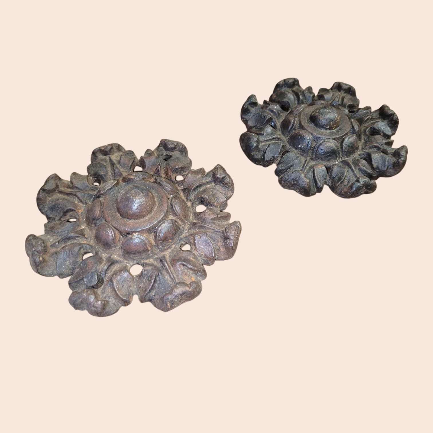 Rosetas de forja antiguas con relieve floral artesanal y acabado envejecido.
