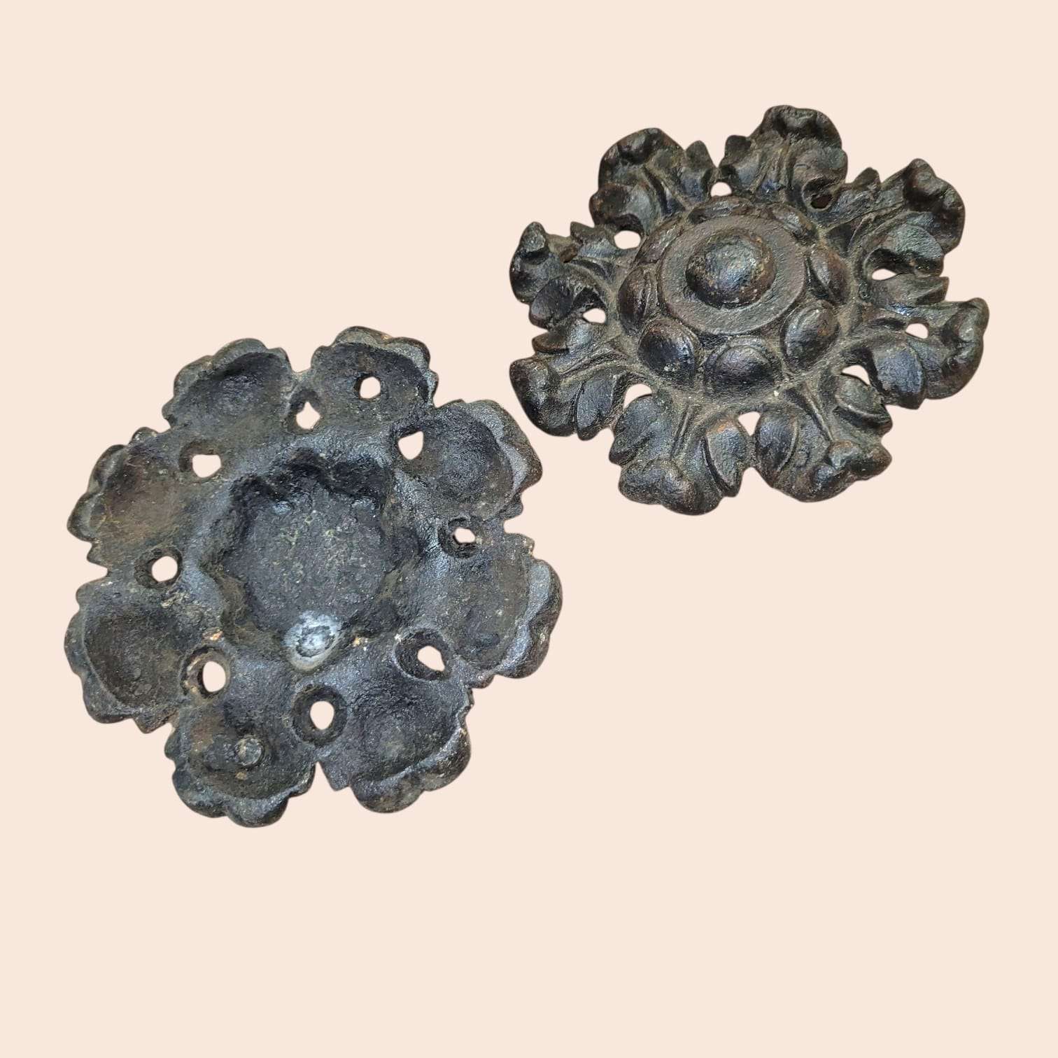 Par de rosetas de hierro forjado con diseño clásico y perforaciones decorativas.