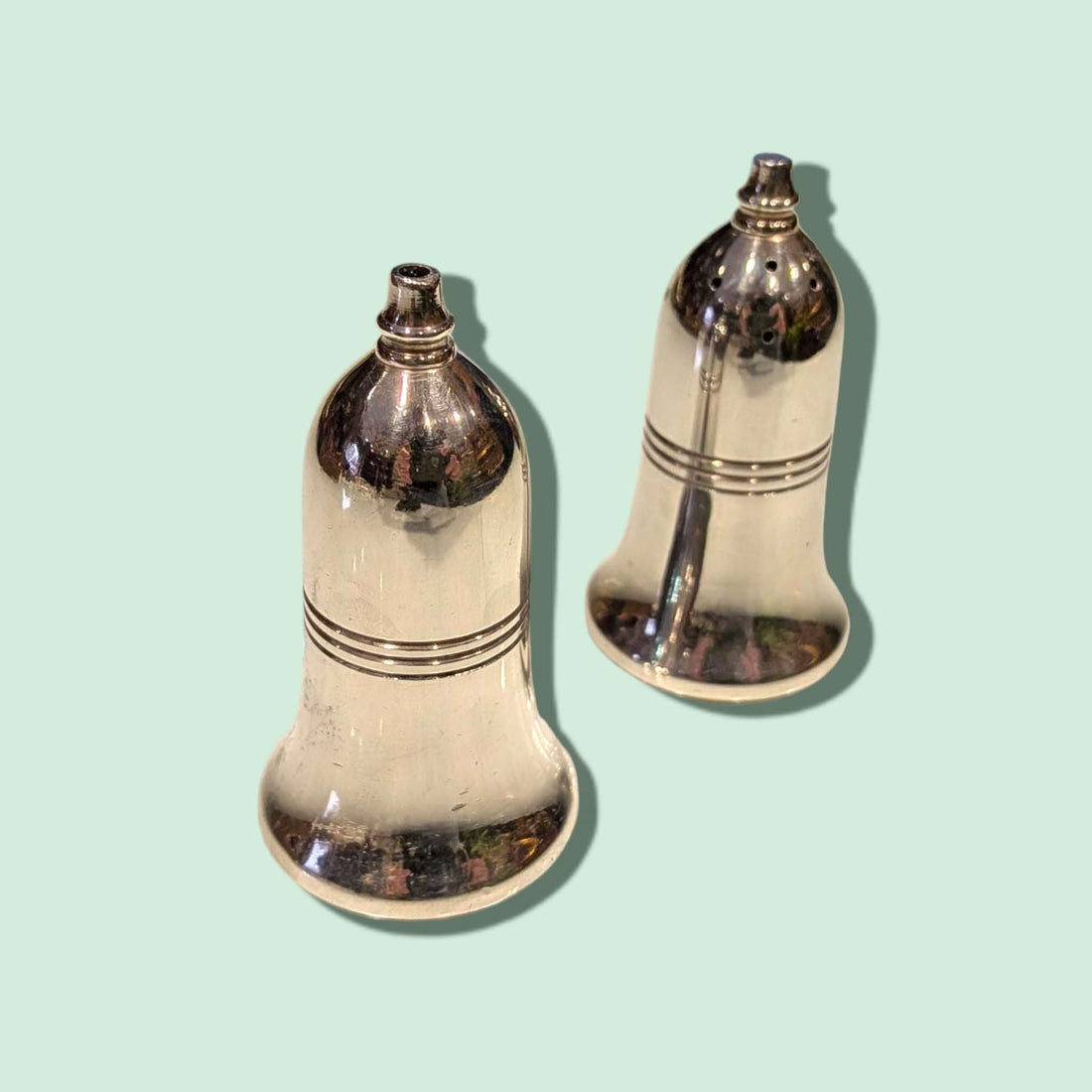 Salero y Pimentero antiguos de metal plateado, vista frontal.