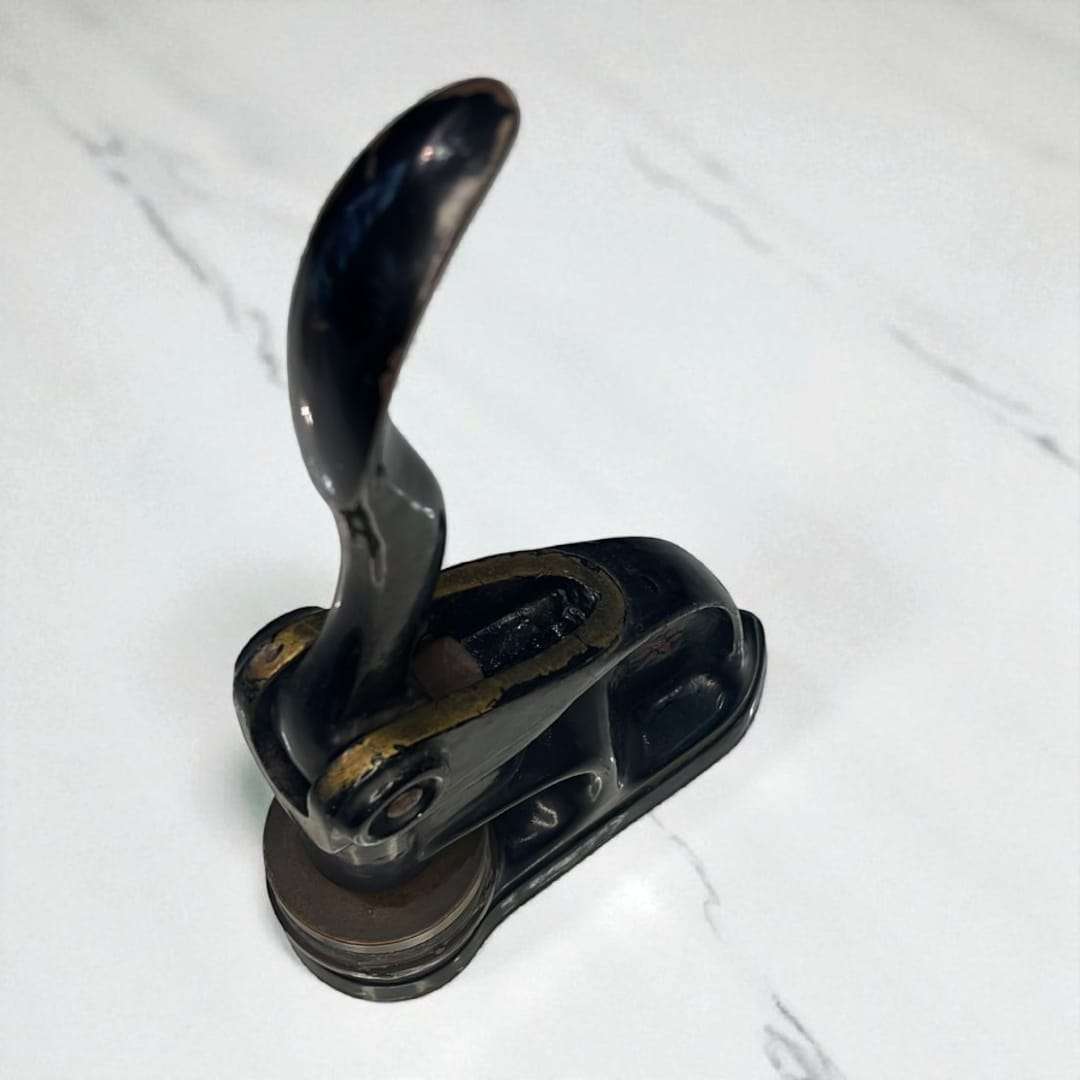 Vista superior del sello de relieve antiguo con palanca cromada.