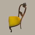 Vista lateral silla vintage estilo Isabelino tapizada en terciopelo amarillo.