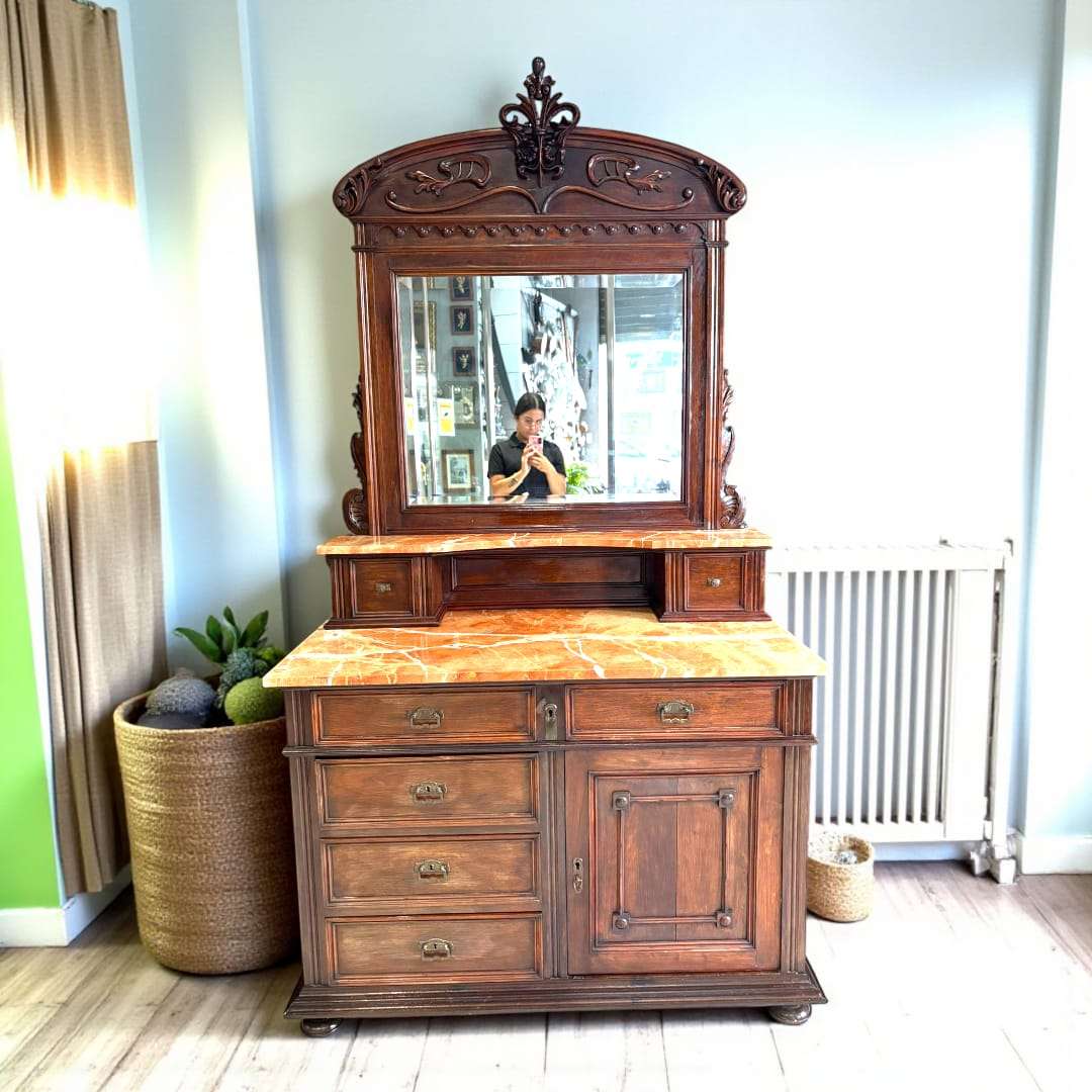 Tocador de caoba con tapa de mármol rojo veteado y espejo biselado.