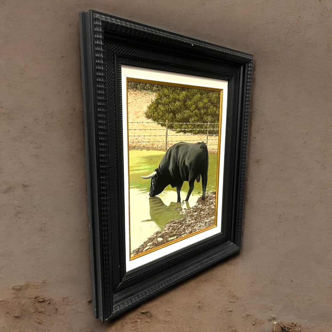 Óleo de toro en el campo por Miguel Parra, enmarcado en negro con detalles dorados. Pintura realista con reflejos en el agua y fondo natural.