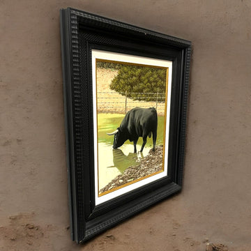 Óleo de toro en el campo por Miguel Parra, enmarcado en negro con detalles dorados. Pintura realista con reflejos en el agua y fondo natural.