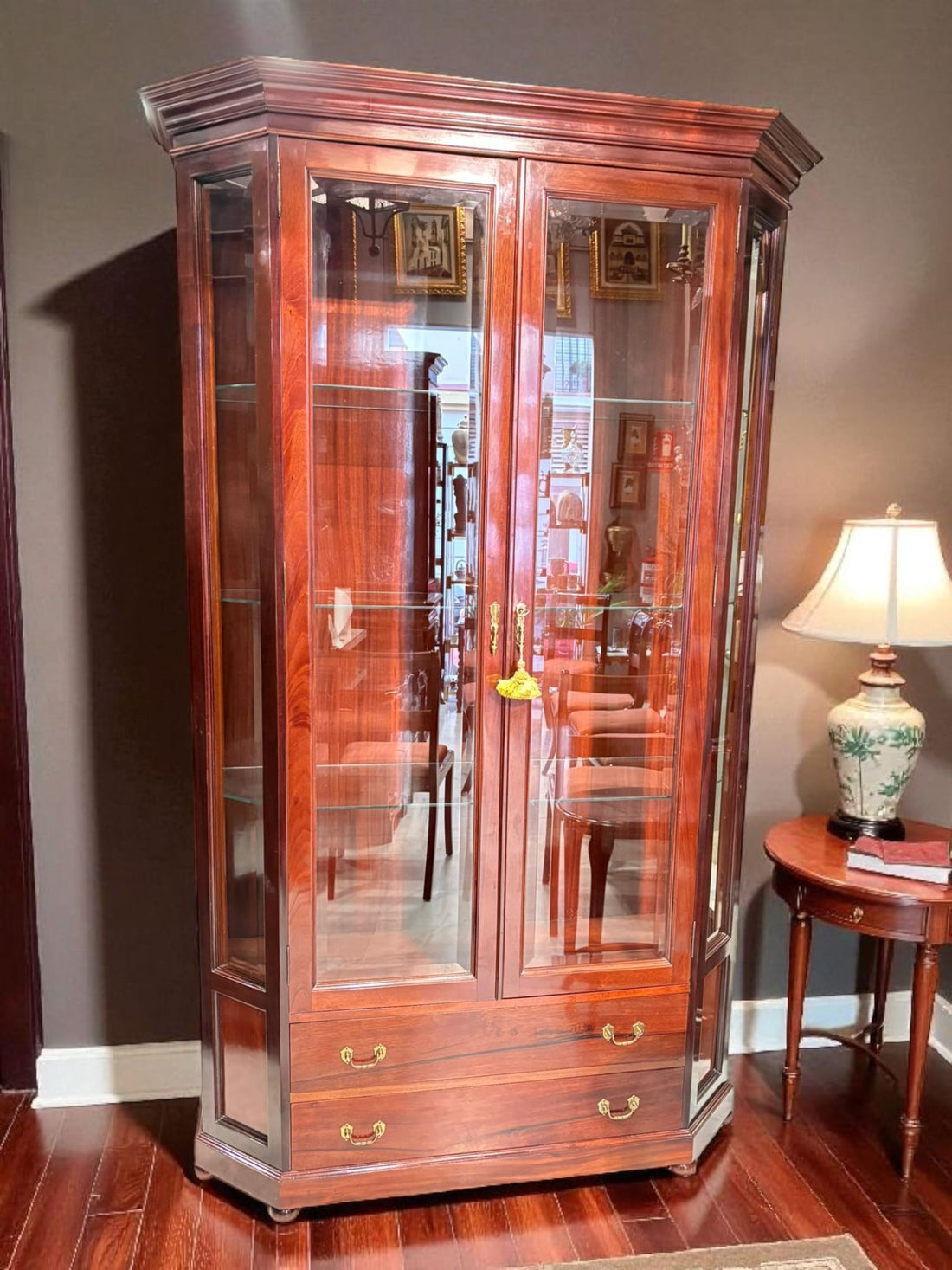 Vitrina de caoba con cristal y cajones – elegancia y distinción, con puertas de vidrio y estantes para exhibir objetos decorativos en interiores.