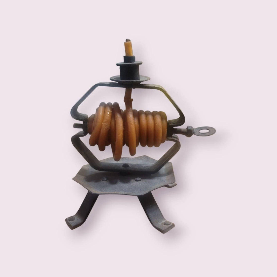 Palmatoria antigua de hierro forjado con velas en espiral años 80 encendida sobre mesa de madera en sala acogedora. Ideal para decoración vintage.