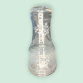 Set ensamblado de botella con vaso de cristal antigua para agua grabada, con motivos florales blancos. Diseño funcional y decorativo para el hogar.