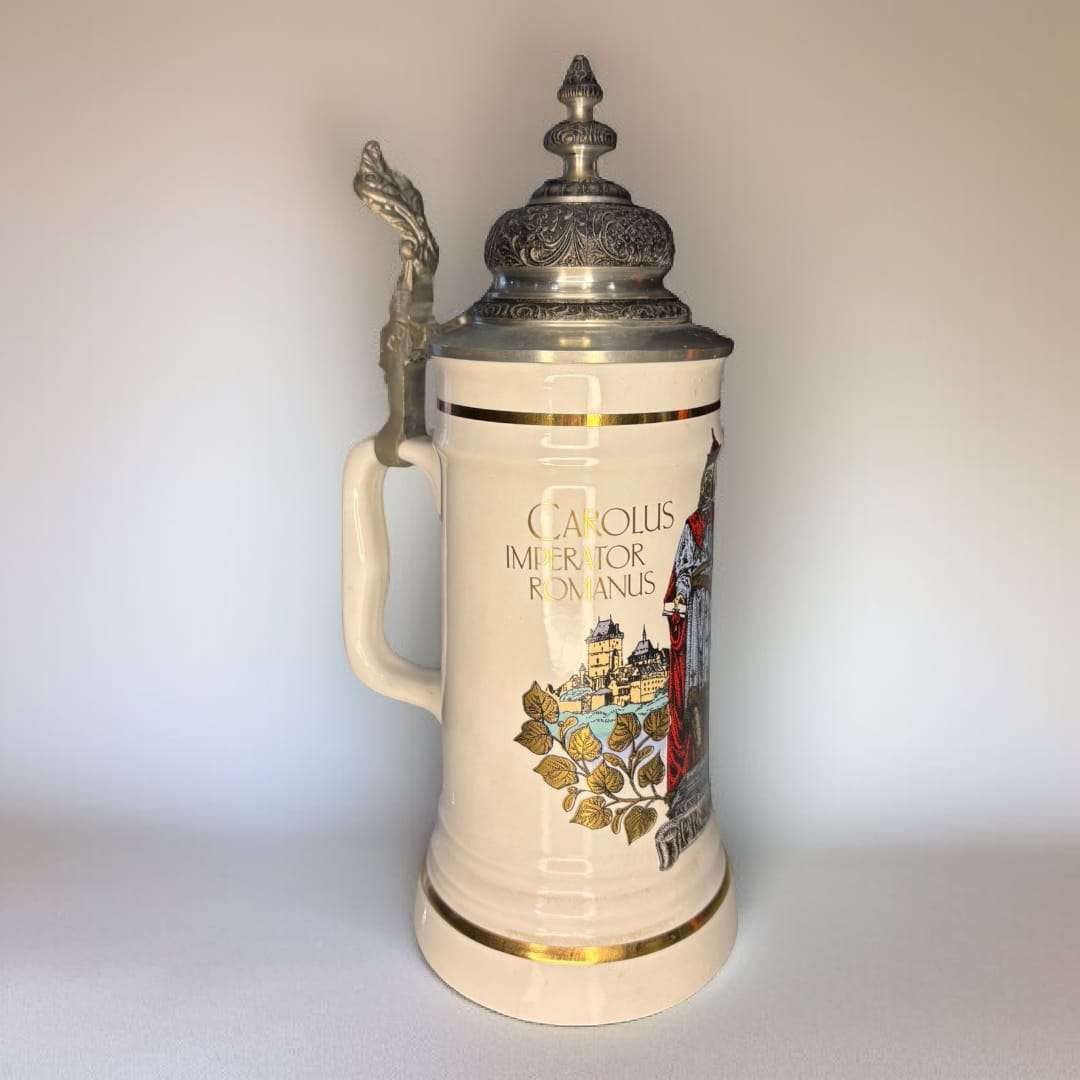 Jarra de cerveza alemana de porcelana con tapa metal grabada, diseño clásico y texto en latín, sobre mesa antigua en sala elegante. Ideal para decoración vintage.